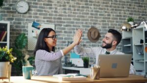 coworkers smiling, high-fiving and getting along